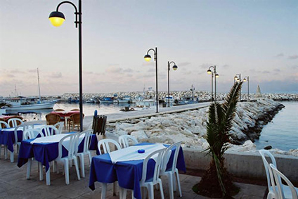 Boats and waterfront tables beside Latchi harbour